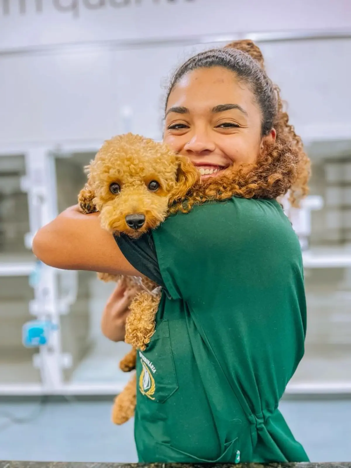 Profissional em ambiente veterinário segurando um cachorro